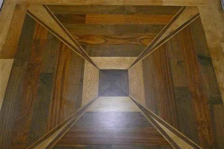 Wood floor with an optical illusion of a three-dimensional box.
