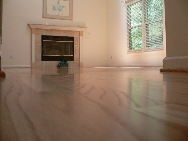 Living room with light wood floor, fireplace, and window with a view.