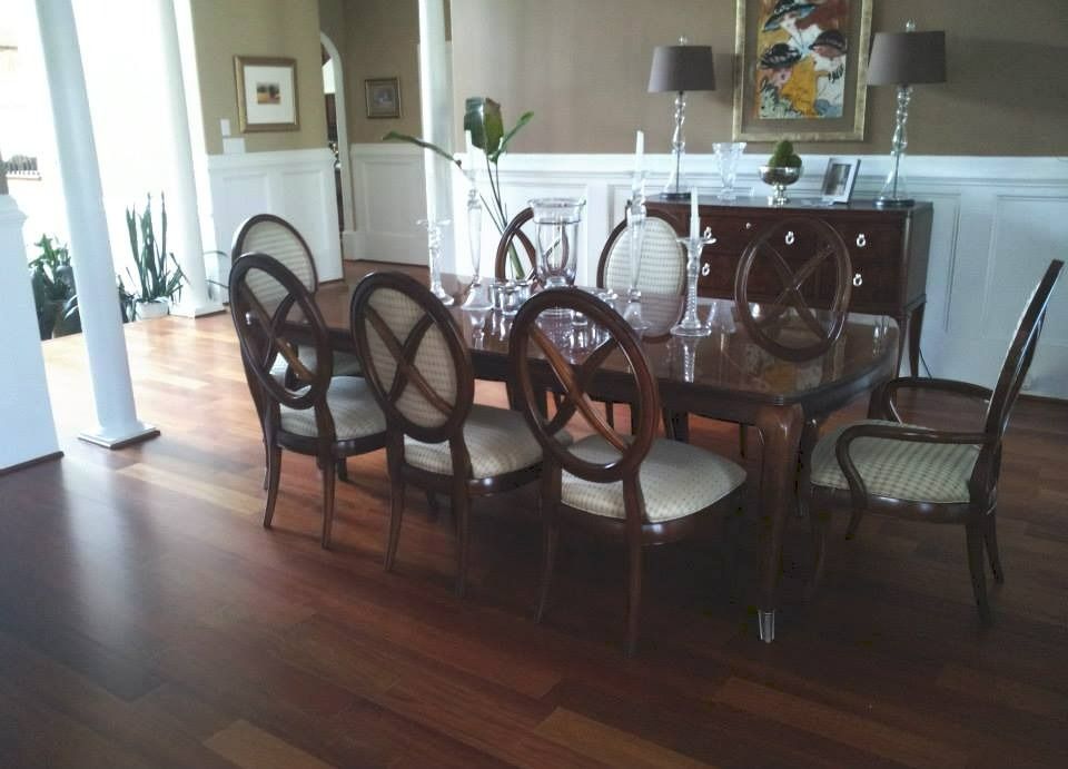 Dining room with a wooden table and eight chairs set on a hardwood floor.