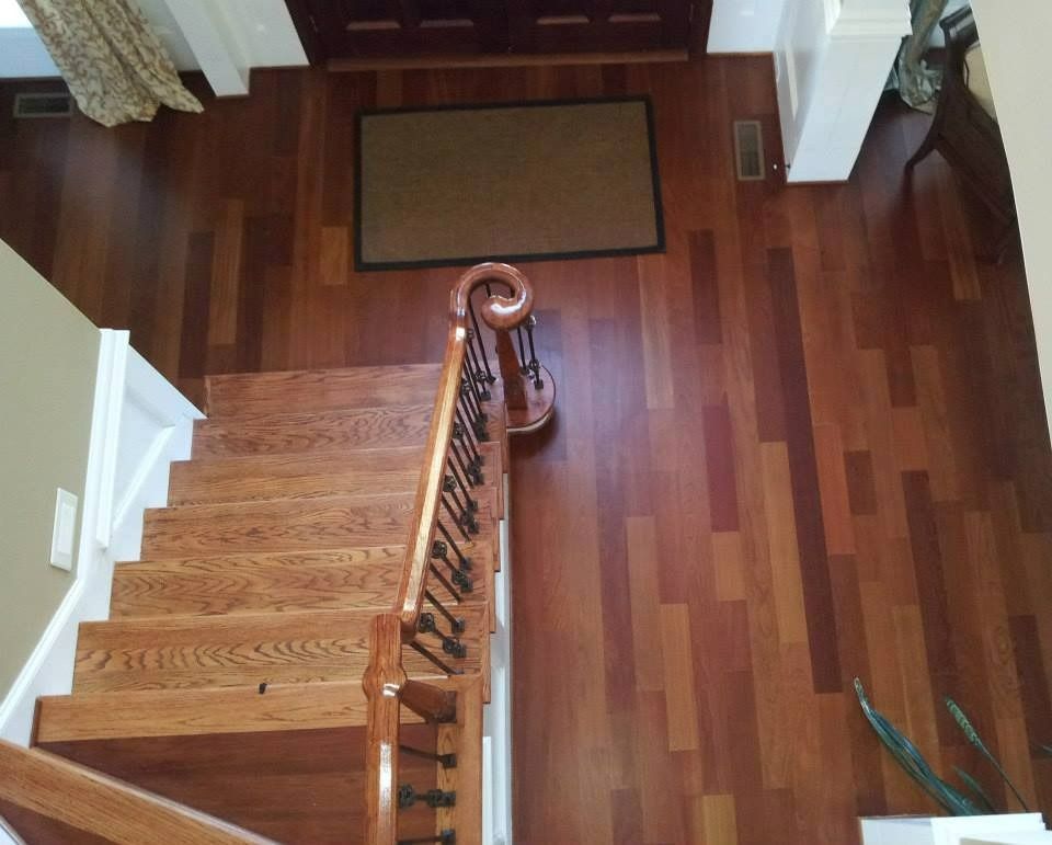 Wooden staircase and hardwood floor in a home entryway, view from above.