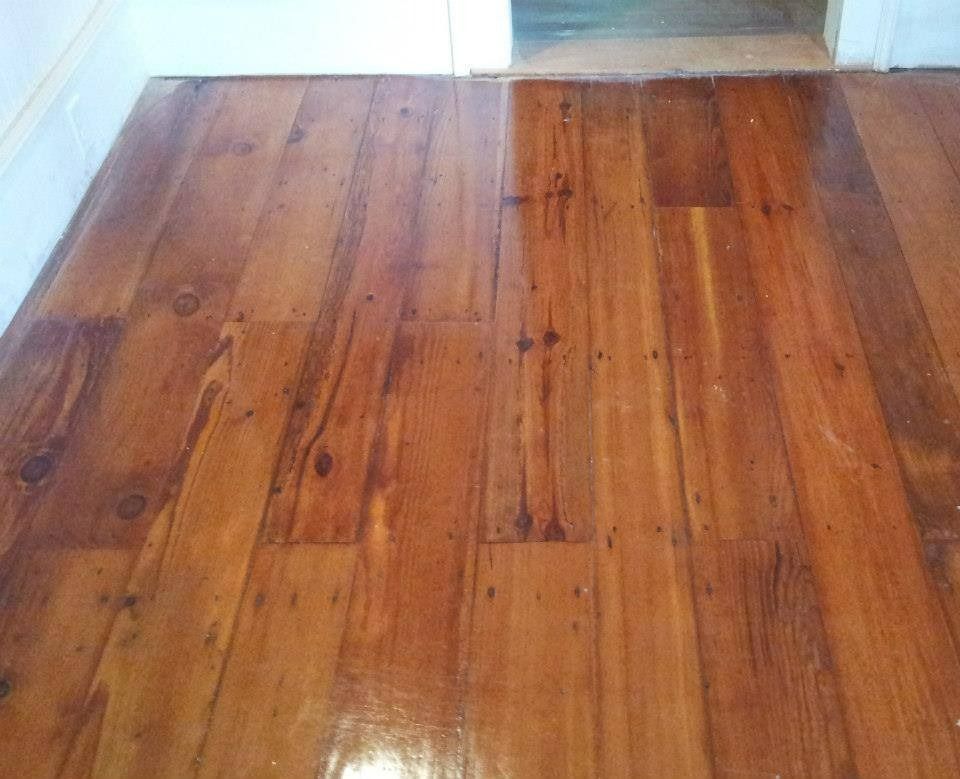 Wooden floorboards, varnished to a glossy sheen. Brown tones with wood grain visible.