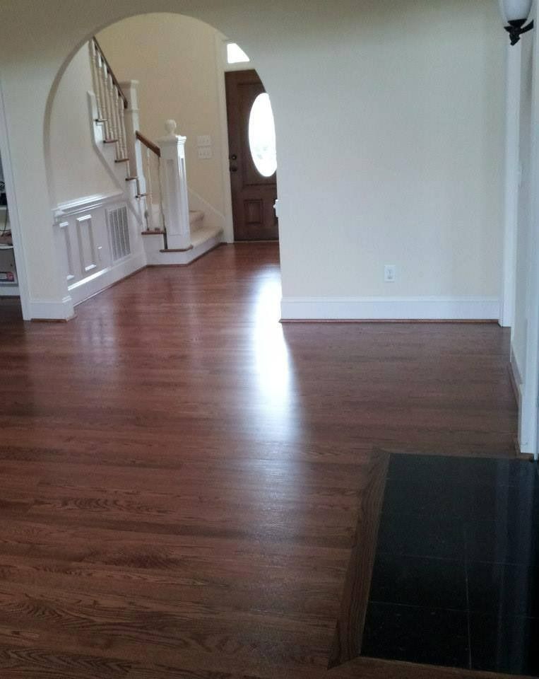 Hardwood floor, doorway, stairs, and entry hall with a bright light reflection.
