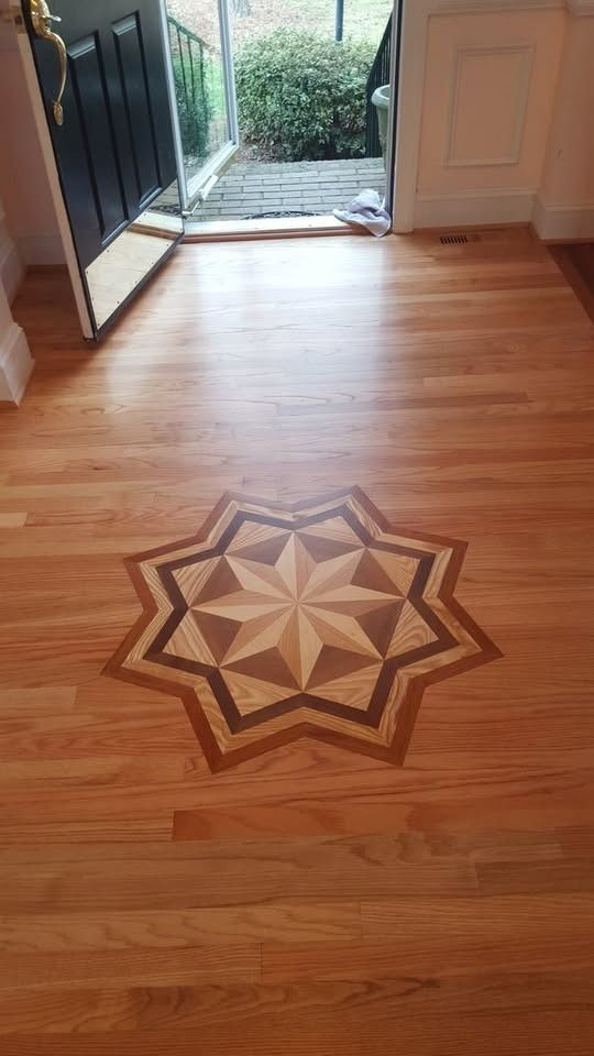 Hardwood floor with a geometric star inlay, leading to an open doorway.