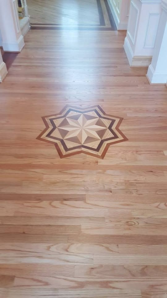 Wooden hallway floor with a starburst inlay.