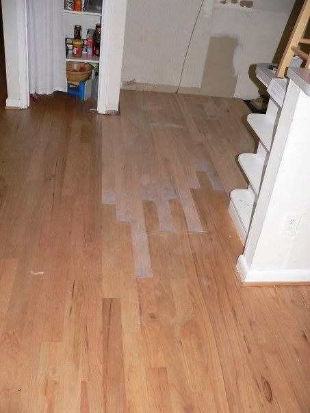 Wooden floor partially refinished; light patch contrasts with darker wood.