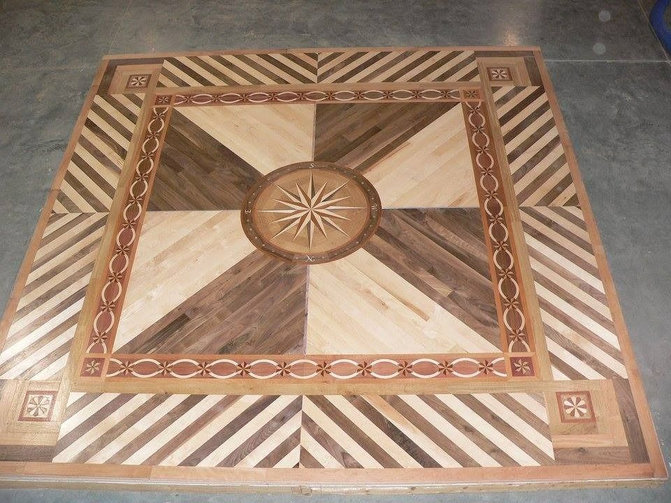Detailed wooden floor inlay with a compass rose design and geometric patterns.