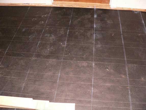 Dark tiled floor marked with white lines, likely for installation.