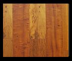 Wood grain with varying shades of brown and visible knots, vertical lines, possibly a table surface.
