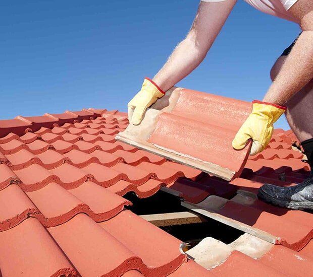 A man installing a roof tile