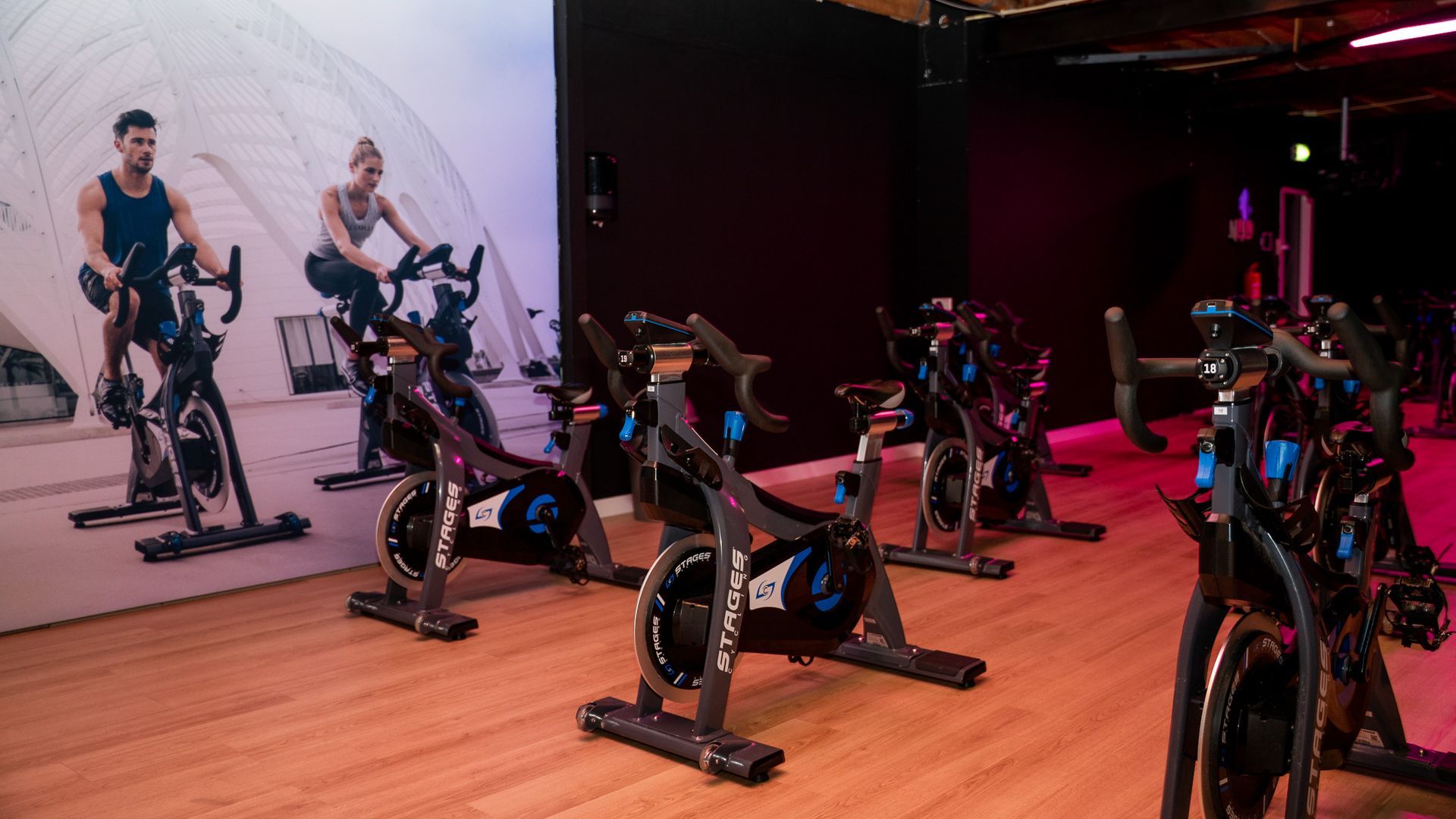 Een vrouw rijdt op een hometrainer in een sportschool.