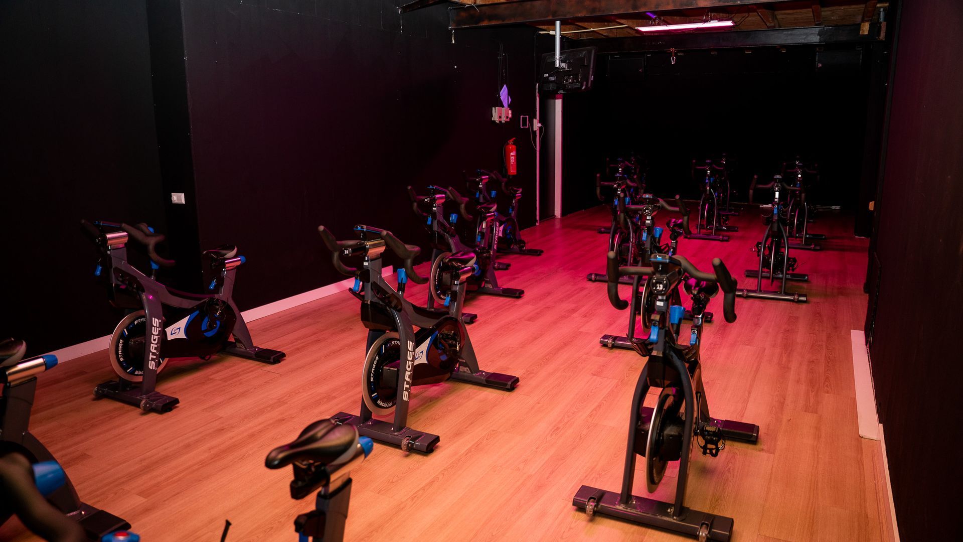 Een groep mensen rijdt op hometrainers in een sportschool.