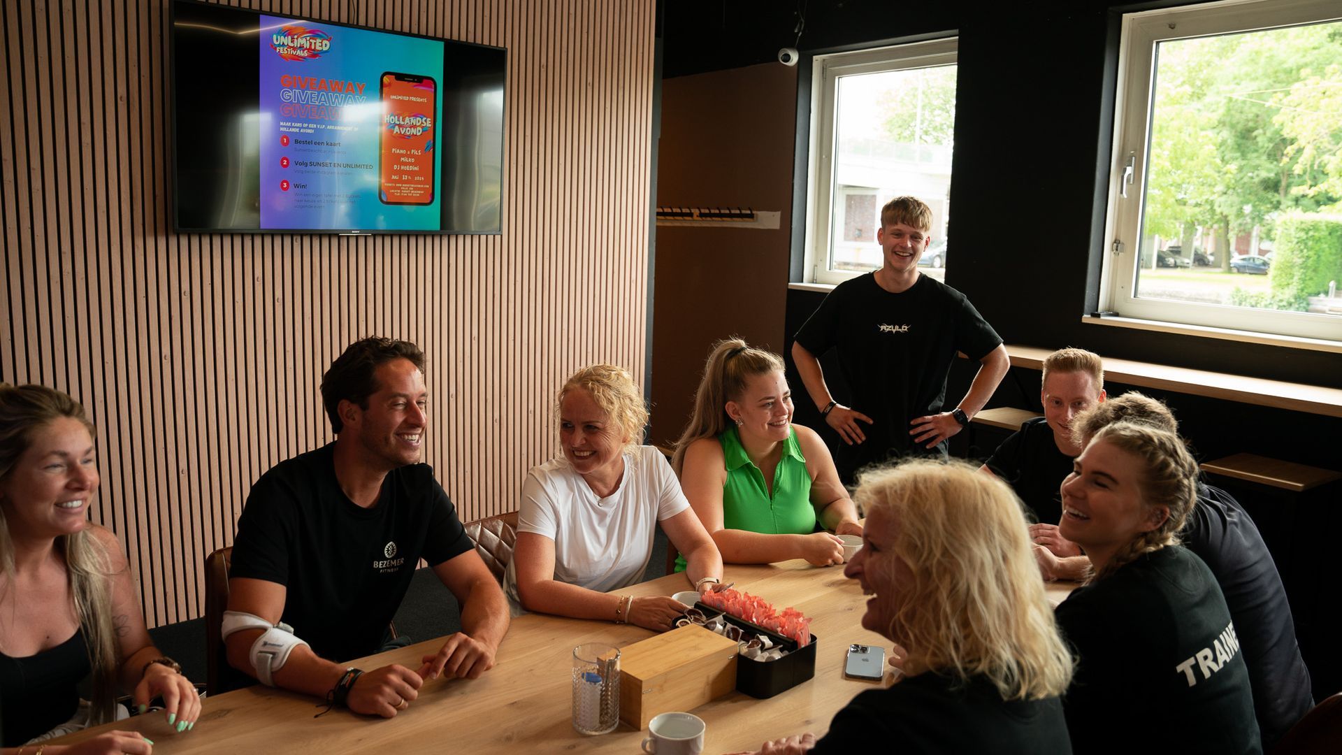 Een groep mensen doet oefeningen op loopbanden in een sportschool.