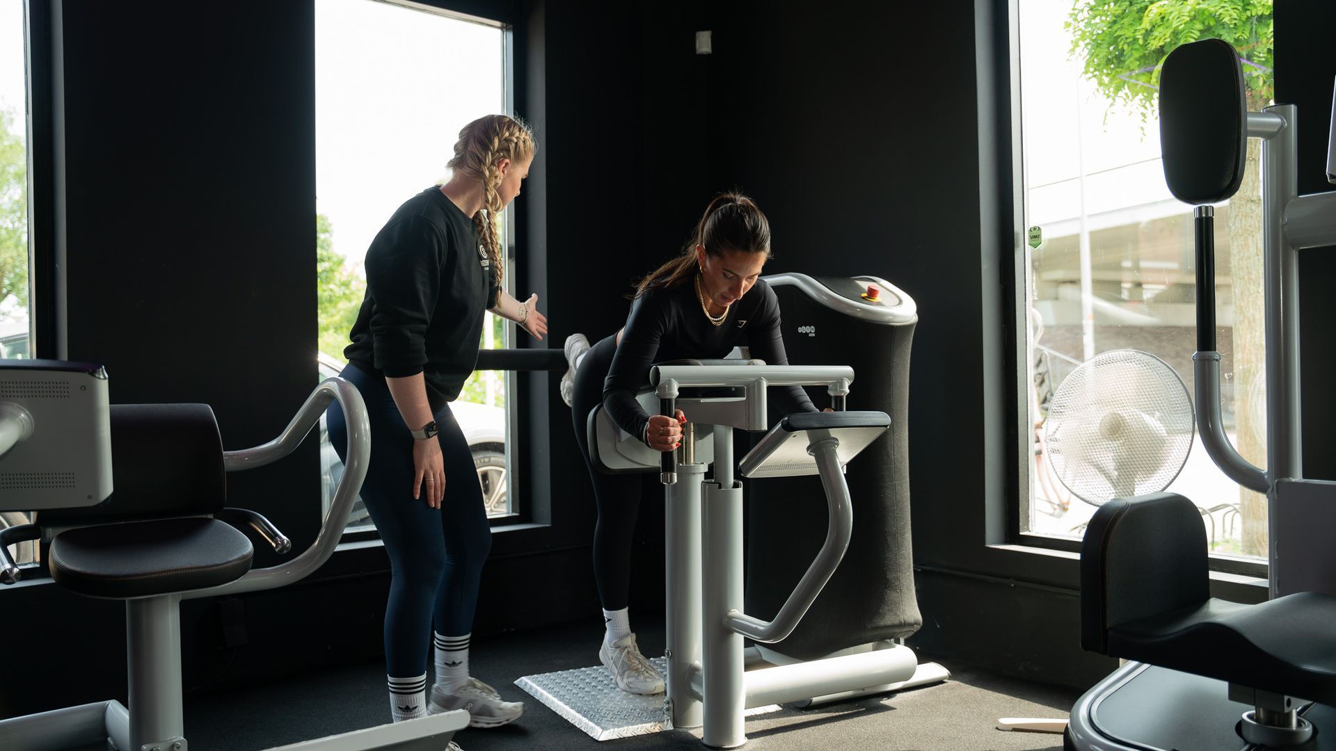 Twee vrouwen staan naast elkaar in een sportschool.