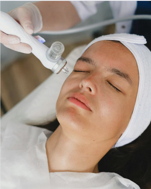 Woman receiving facial treatment with closed eyes in a medical setting.