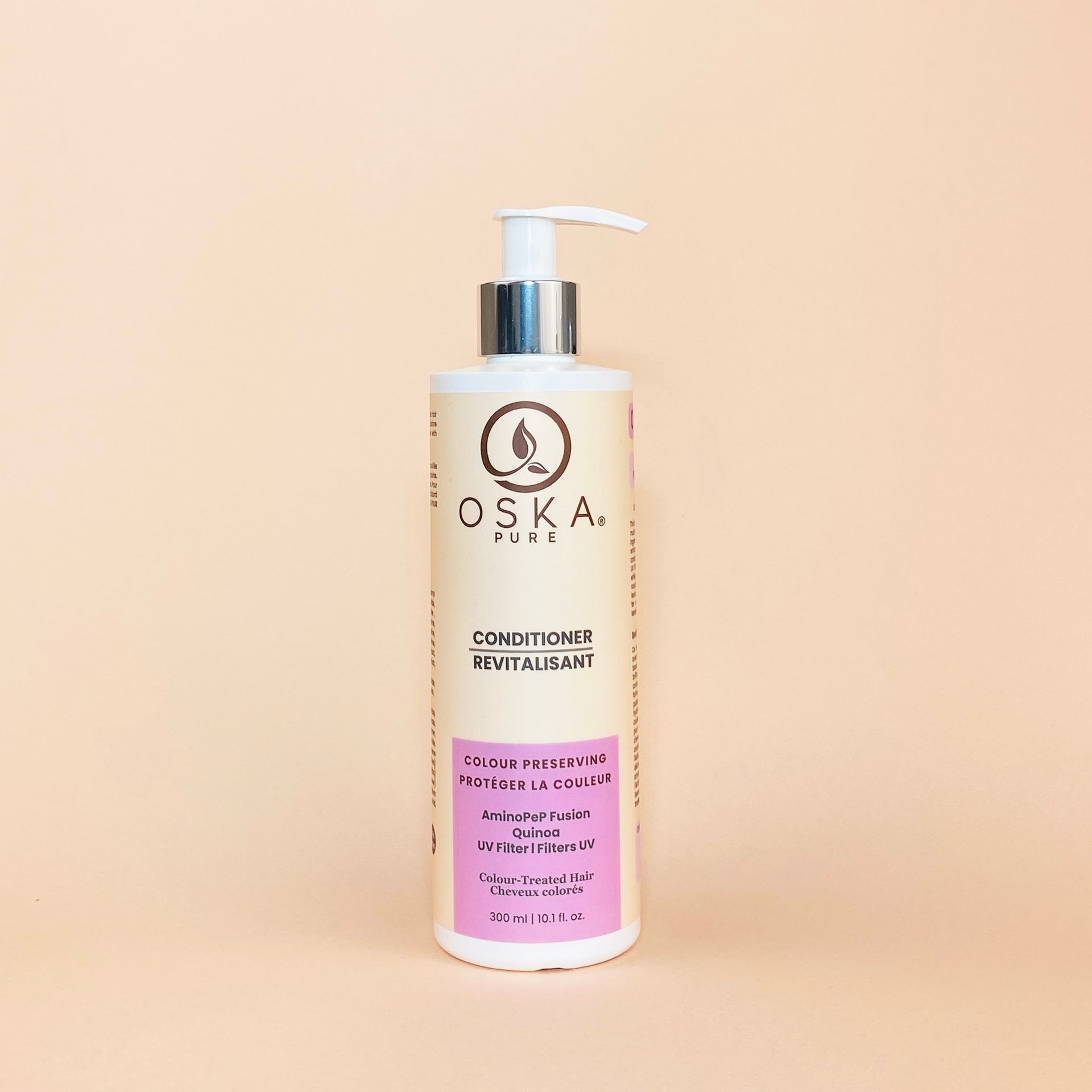 Bottle of OSKA. PURE conditioner with a pump on a peach background.