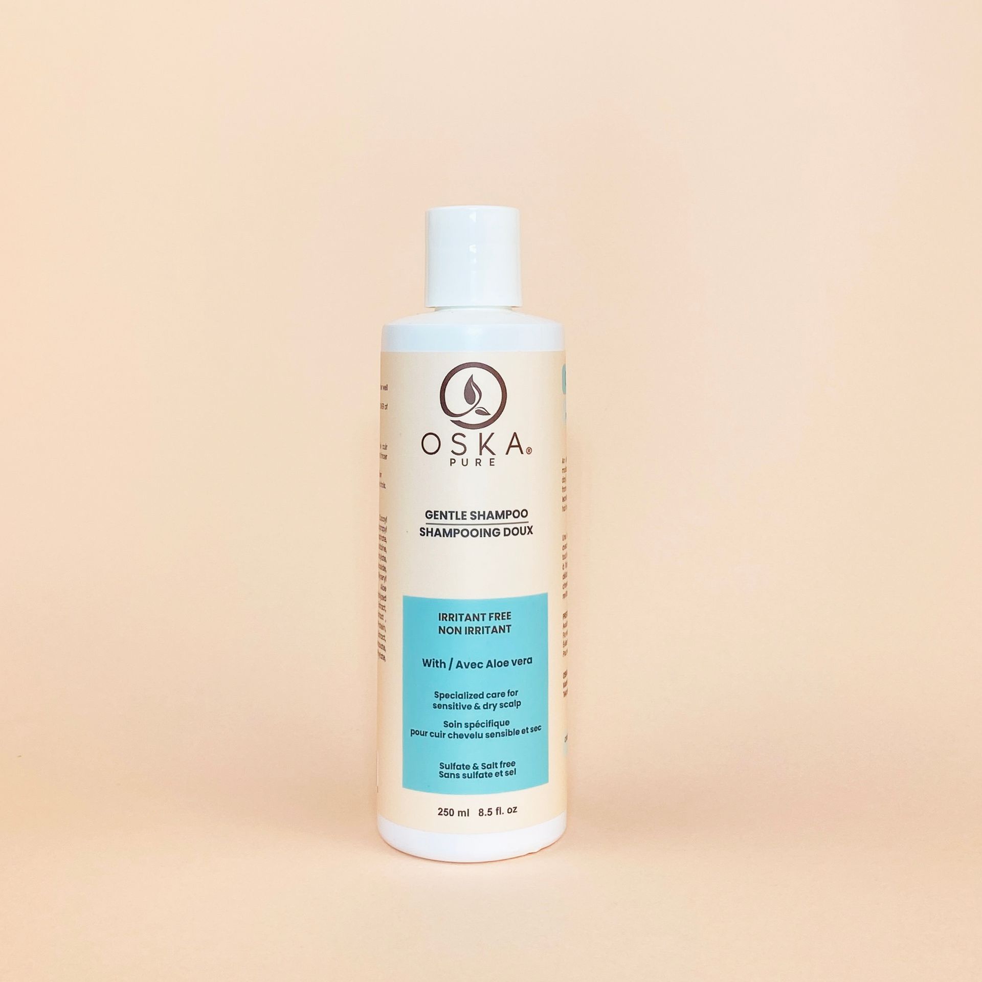 Bottle of OSKA PURE hair care product on a light orange background.