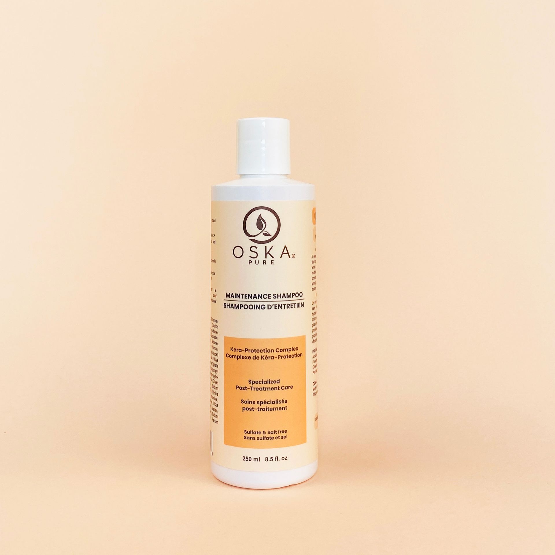 OSKA hair conditioner bottle on a light peach background.