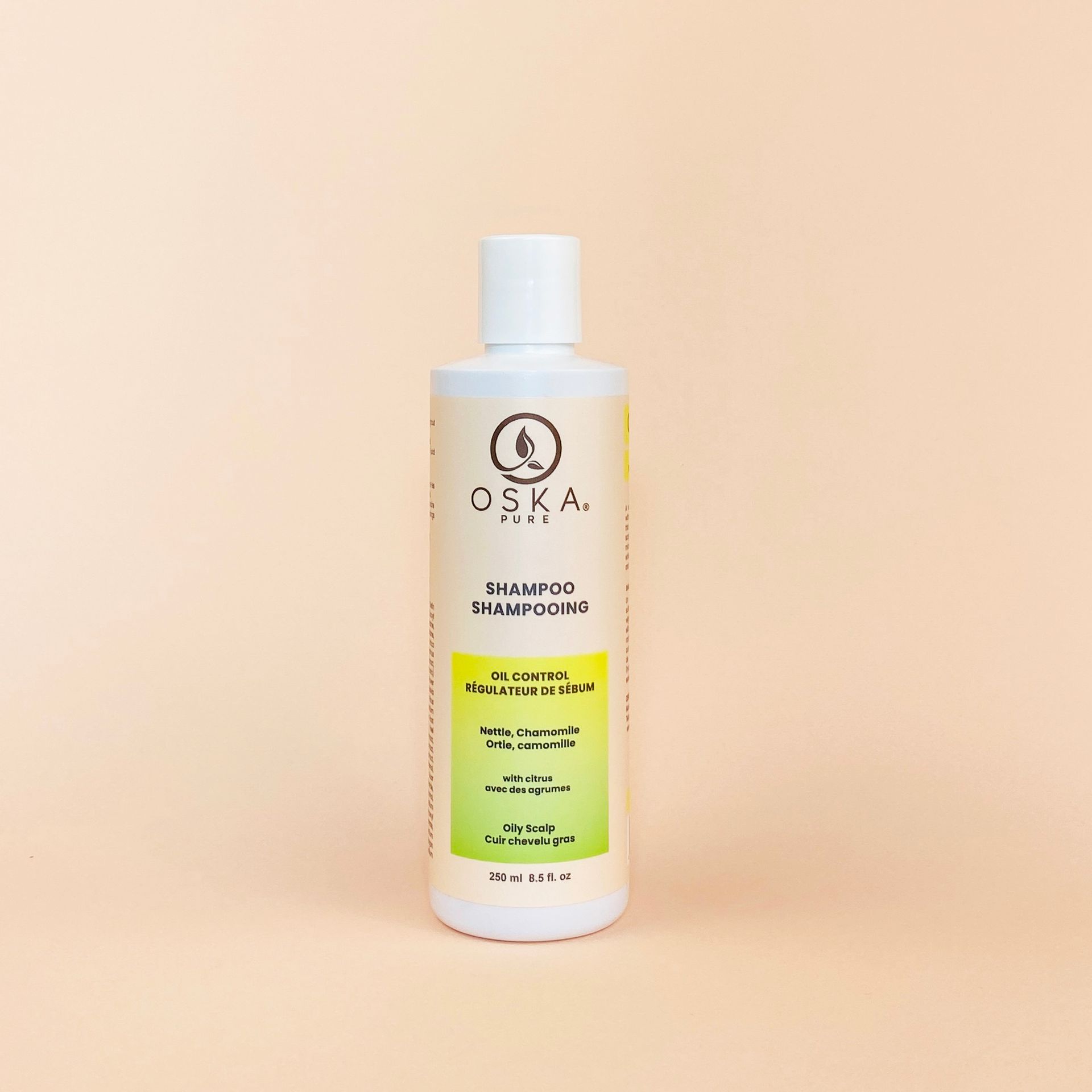 White bottle of OSKA Pure shampoo against a light peach background.
