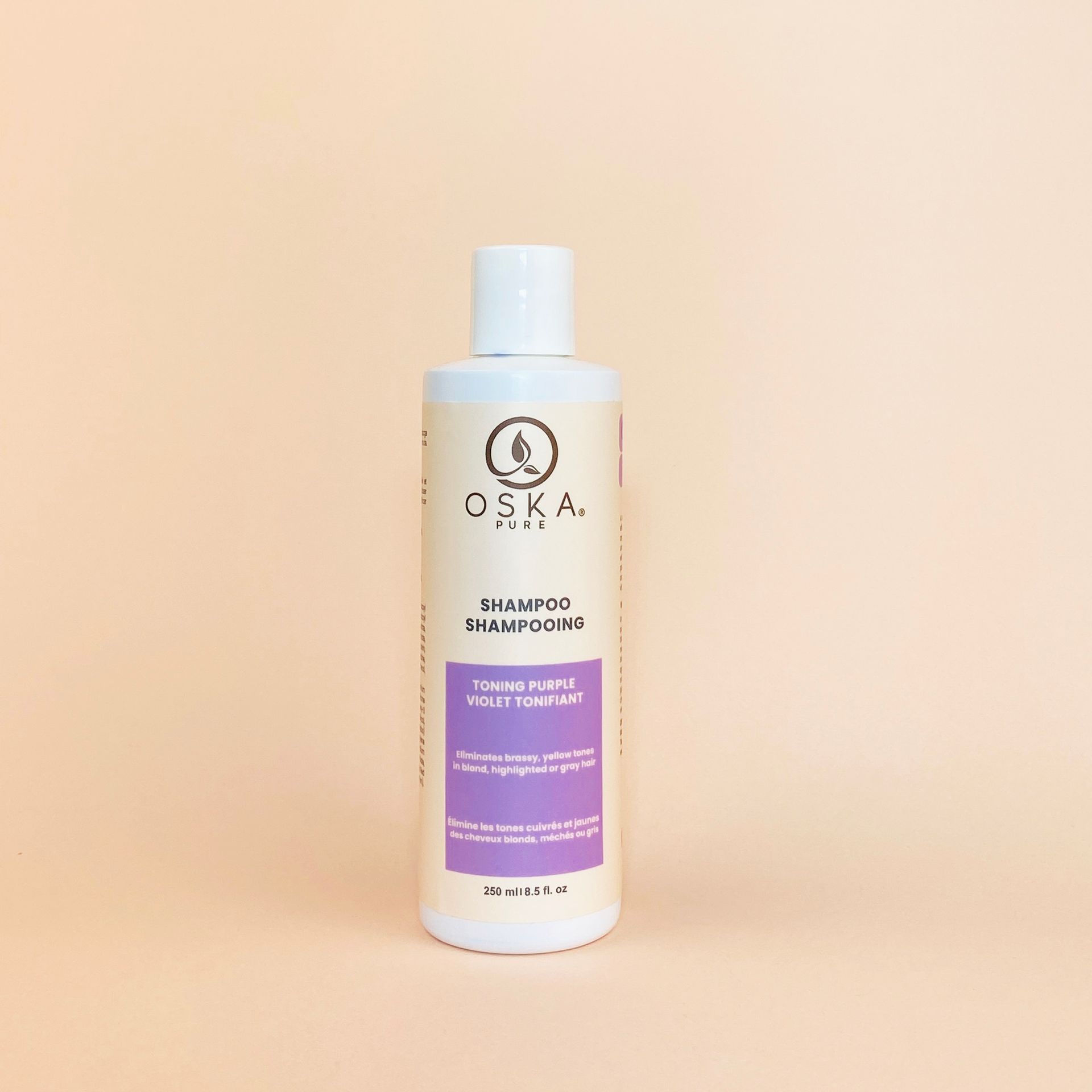 Bottle of OSKA Pure shampoo on a peach background.