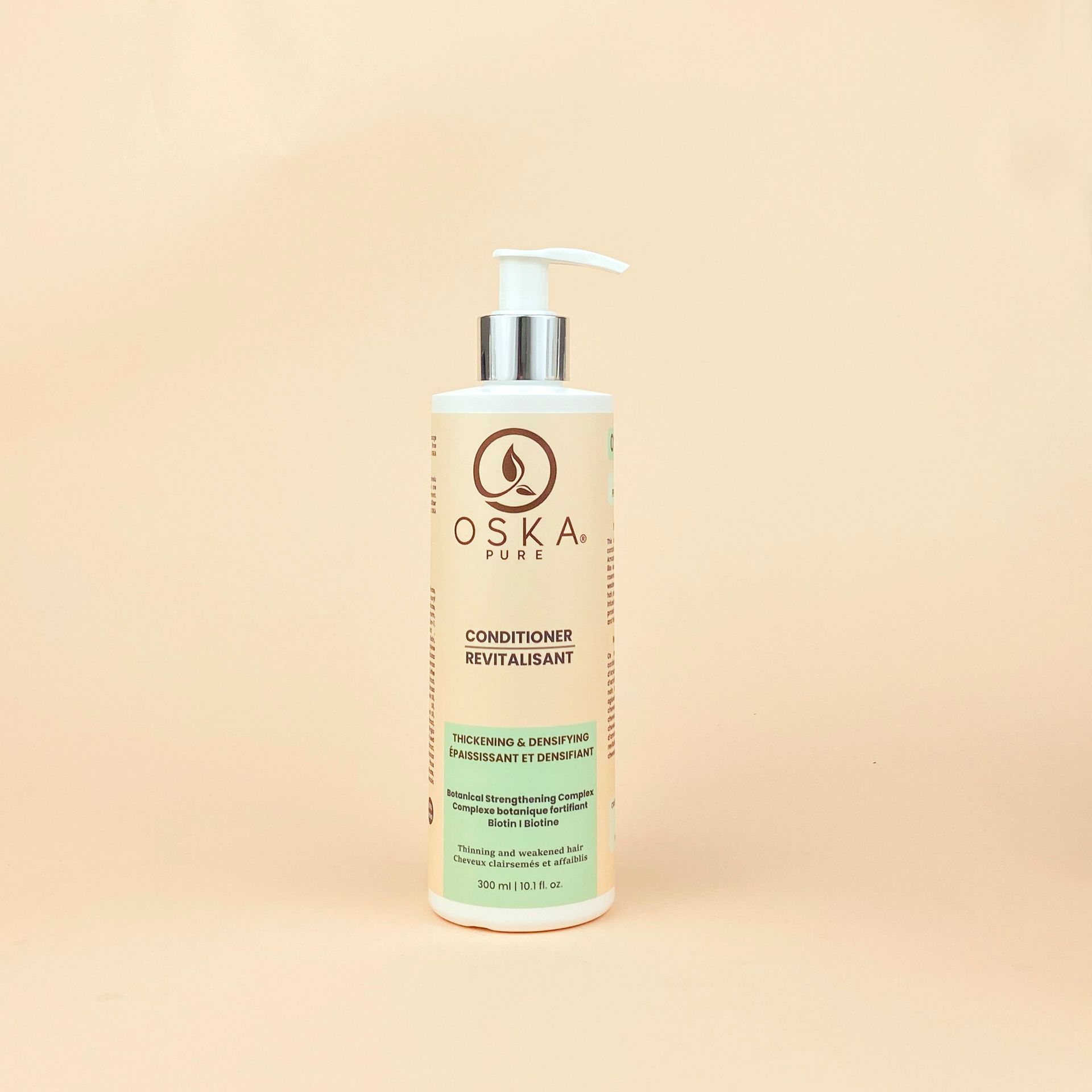 Bottle of OSKA plant body lotion with a pump on a beige background.