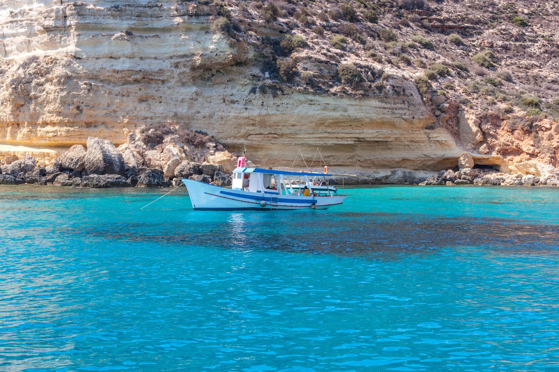 Una barca galleggia sulla superficie di uno specchio d'acqua.