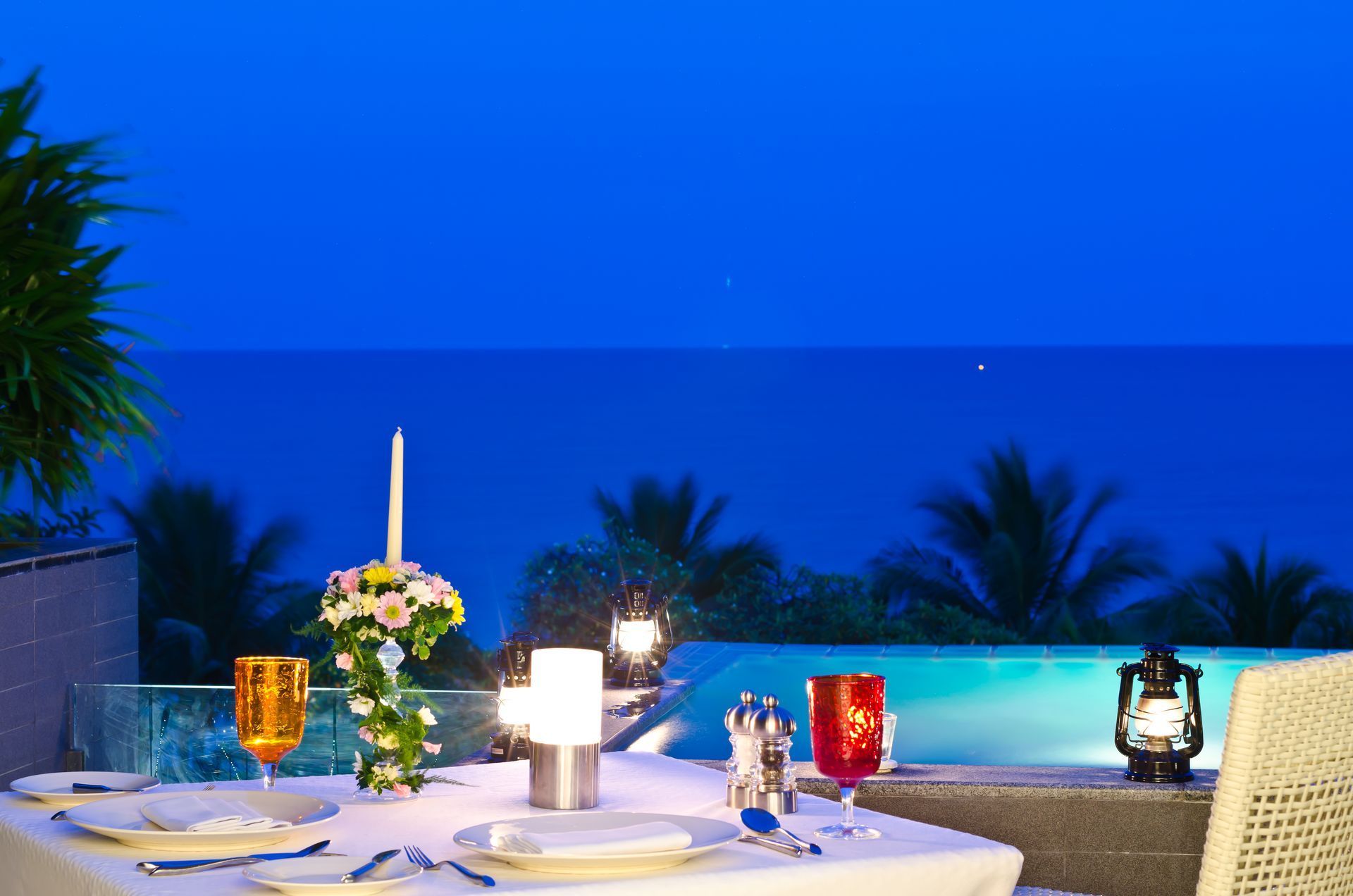 Un tavolo apparecchiato per una cena con vista sull'oceano