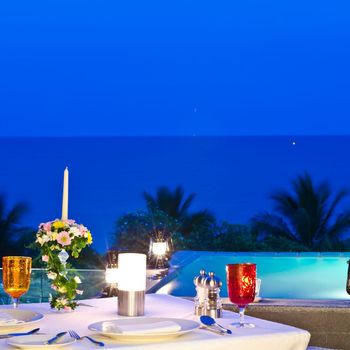 Un tavolo apparecchiato per una cena con vista sull'oceano