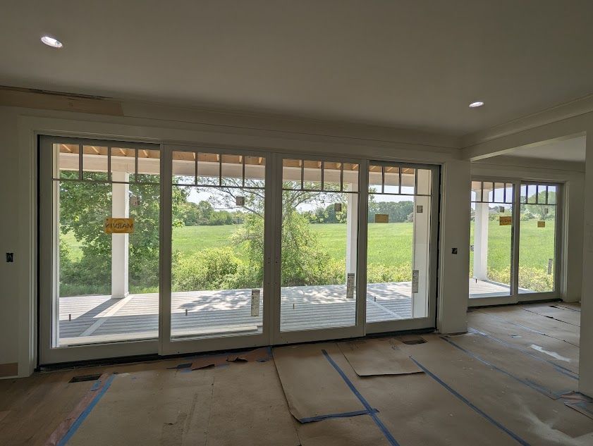 An empty room with a lot of windows and a sign that says no pets