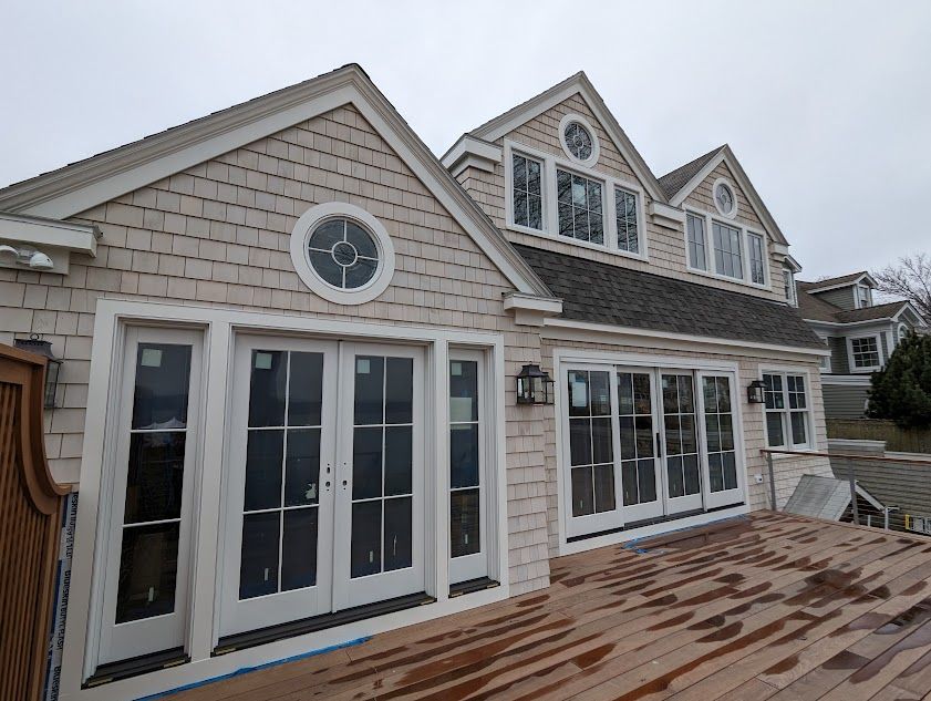 A large house with a lot of windows and doors is being built.