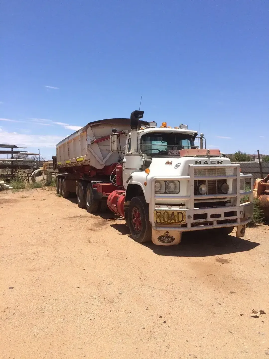 A White Truck With a Red Trailer is Parked in a Dirt Lot — ASPLUM & CIVIL In Alice Springs, NT