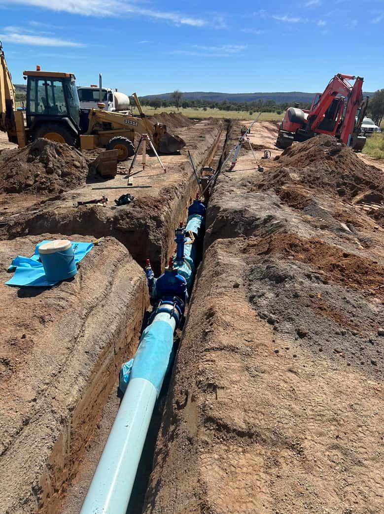 A Pipe is Being Installed in a Trench in the Dirt — ASPLUM & CIVIL In Alice Springs, NT