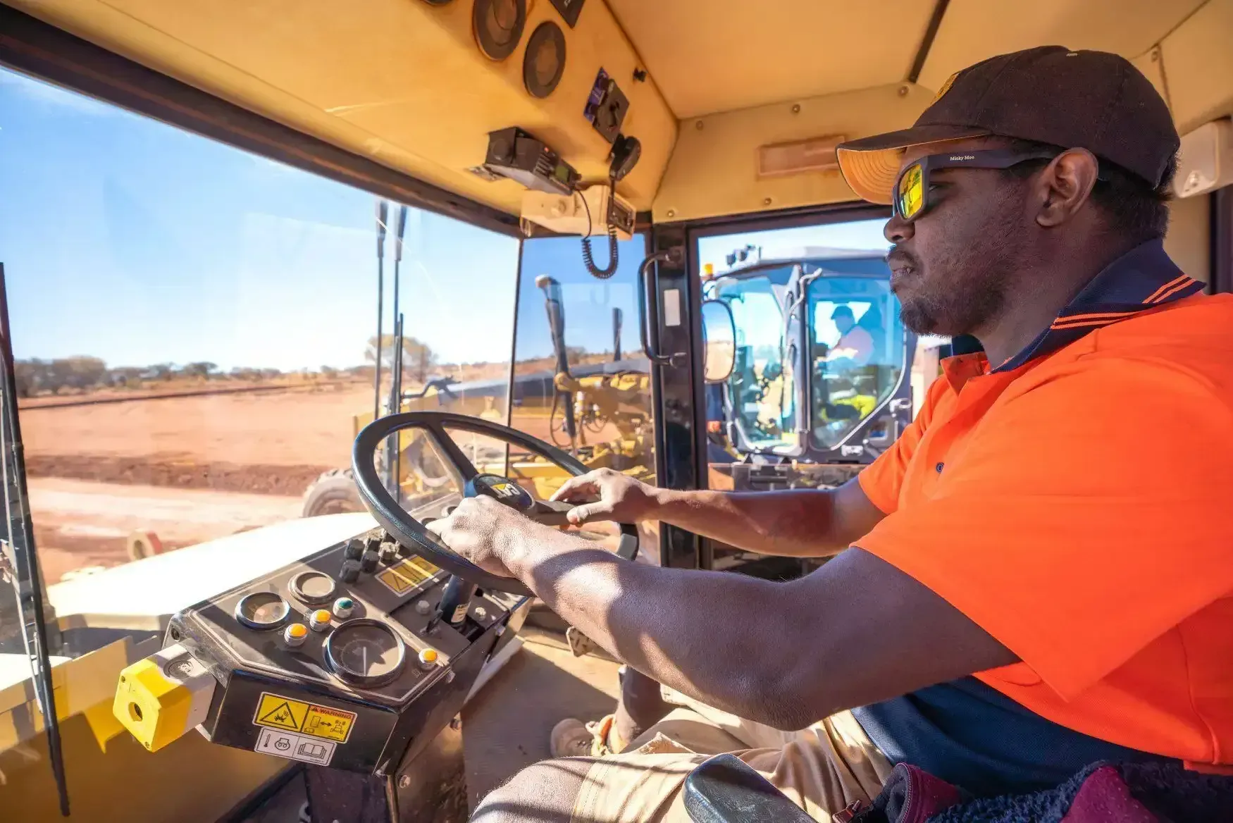 A Man is Driving a Bulldozer on a Dirt Road — ASPLUM & CIVIL In Alice Springs, NT