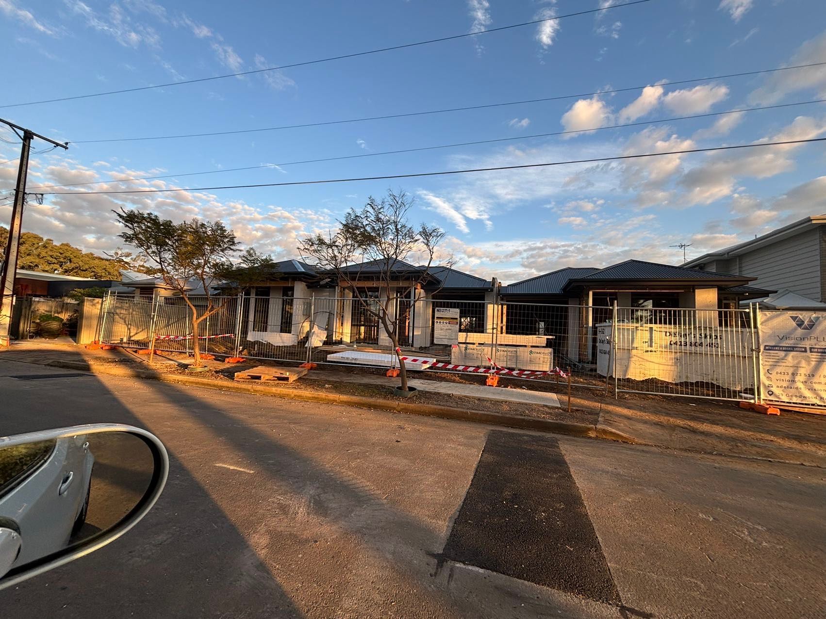 Construction site with two houses under construction, blue sky.