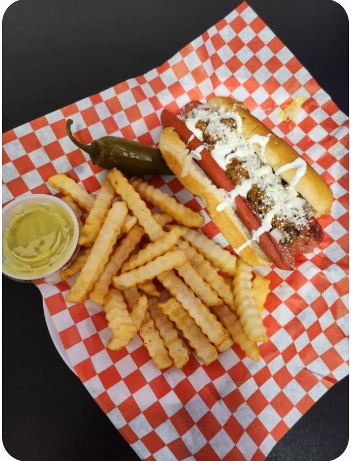 Two hot dogs on a plate with ketchup and mustard.
