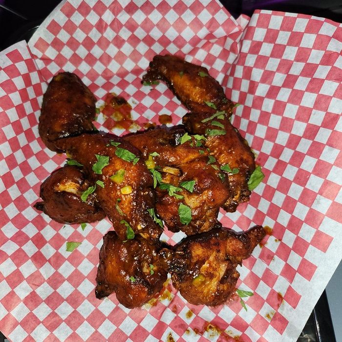 A basket of chicken wings on a checkered paper