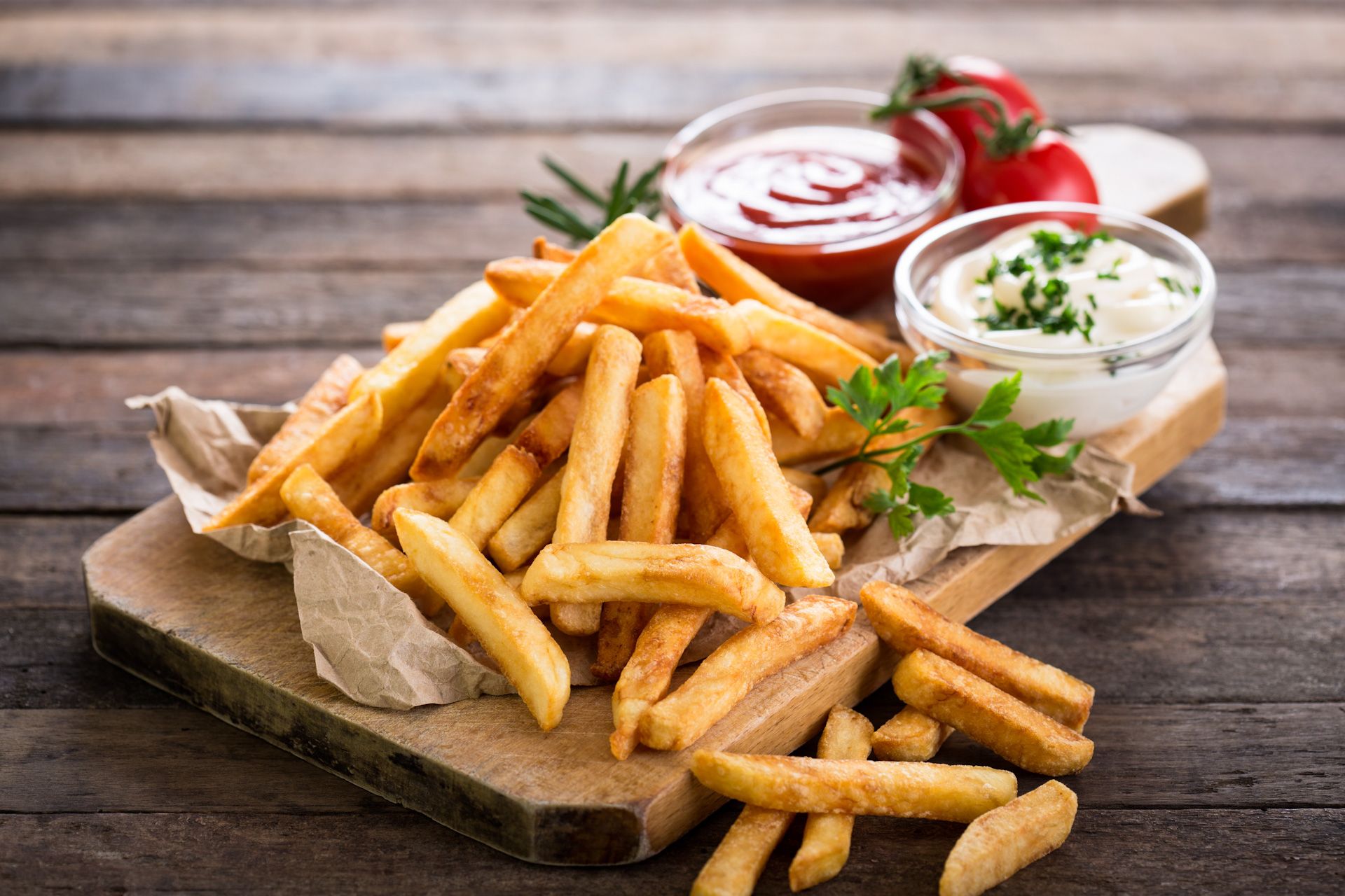 A close up of a plate of french fries with a dipping sauce.