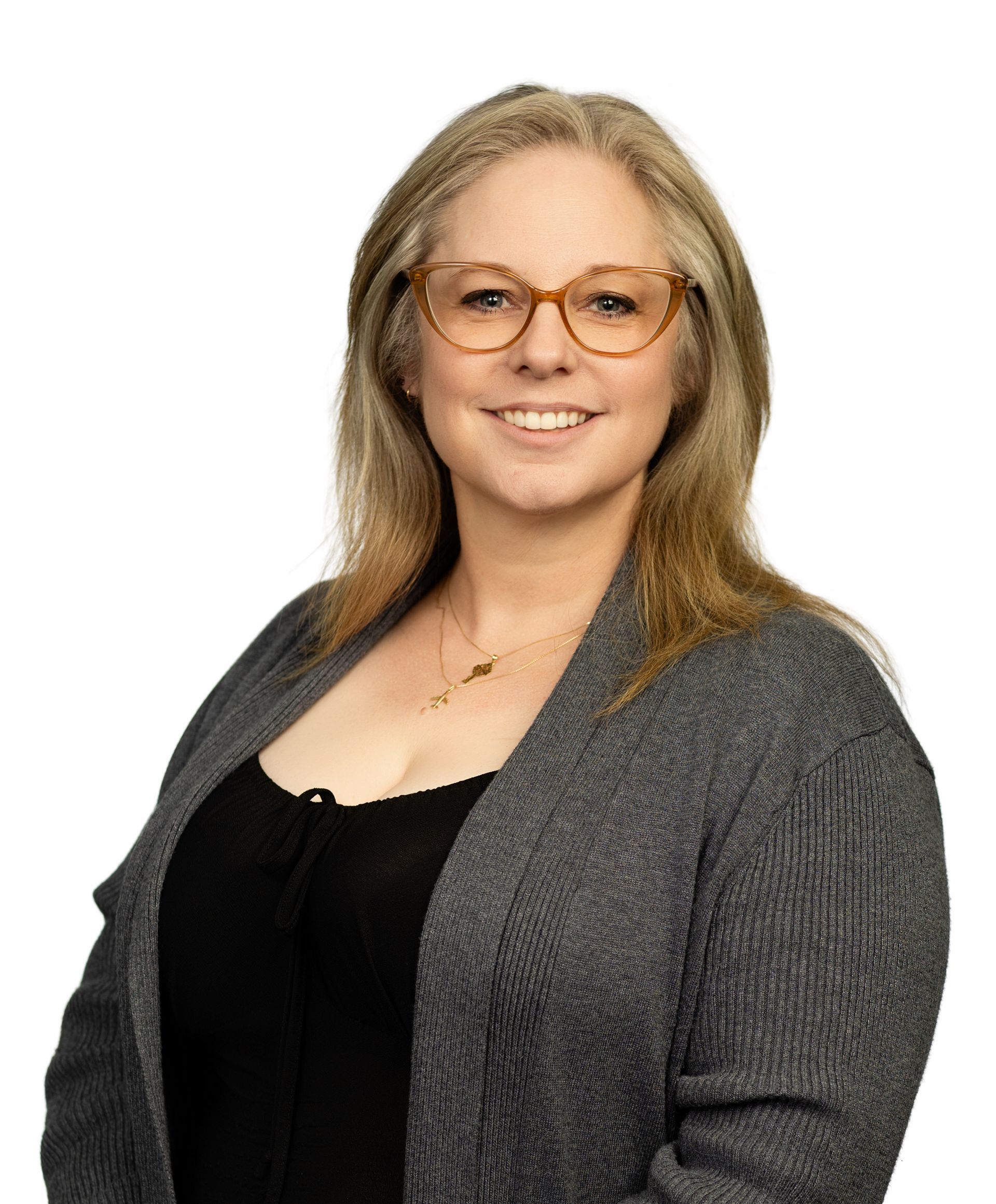A woman wearing glasses is touching her face with her hand.