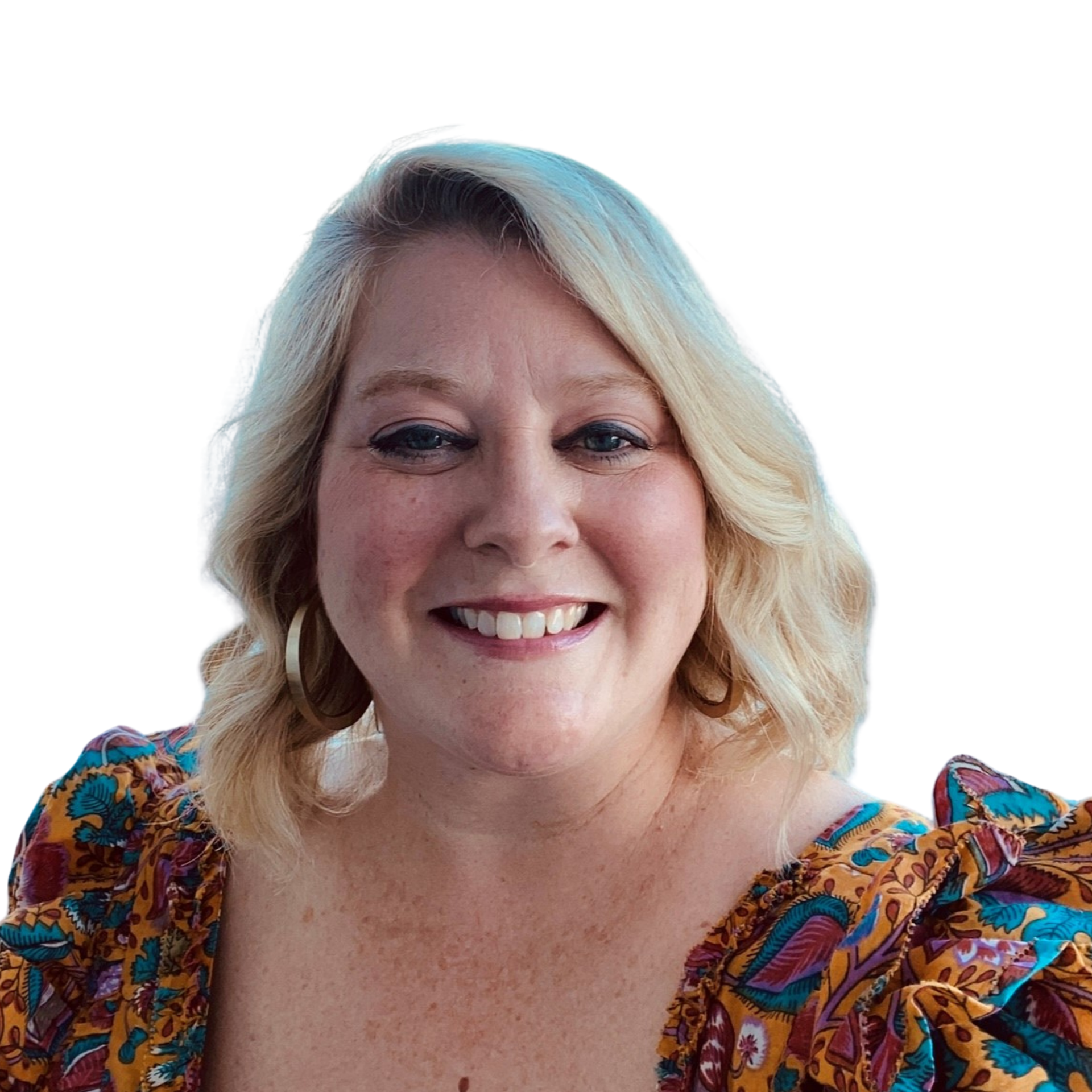 A woman in a floral dress is smiling in front of a white background.
