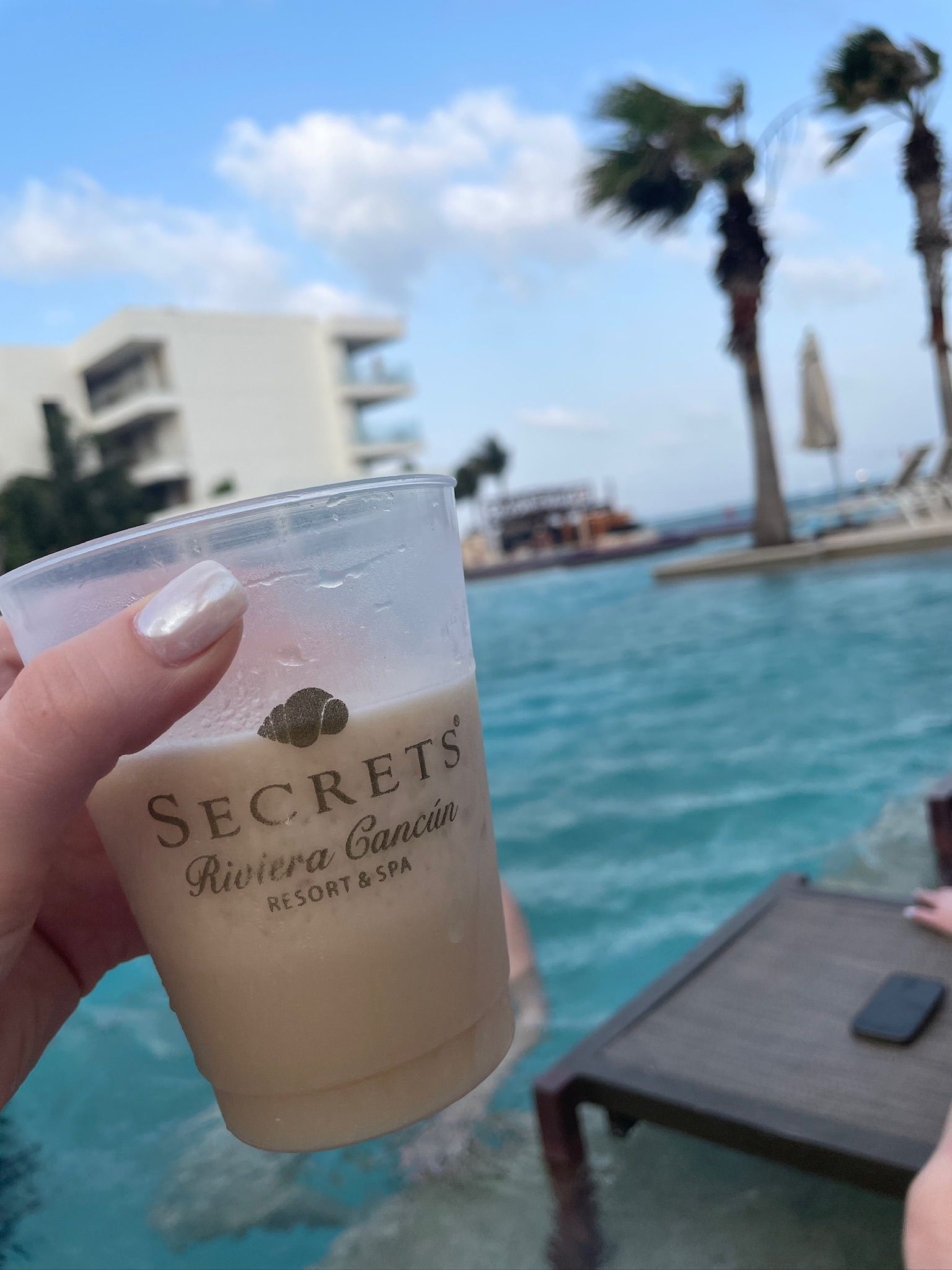 A person is holding a cup that says secrets on it