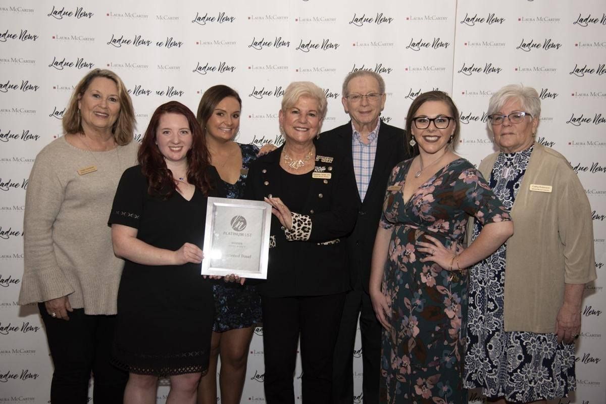group of women and a man holding an award A group of women standing next to each other holding a certificate.
