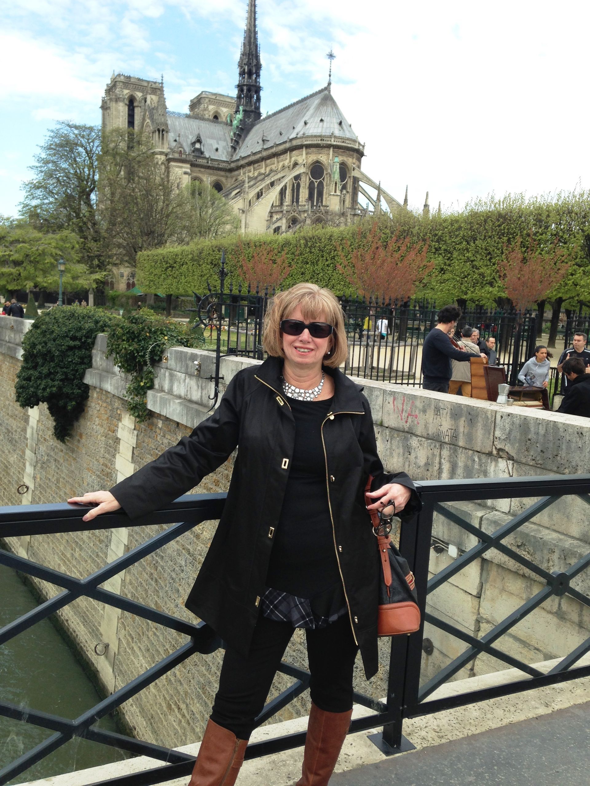 A woman standing on a bridge with a cathedral in the background