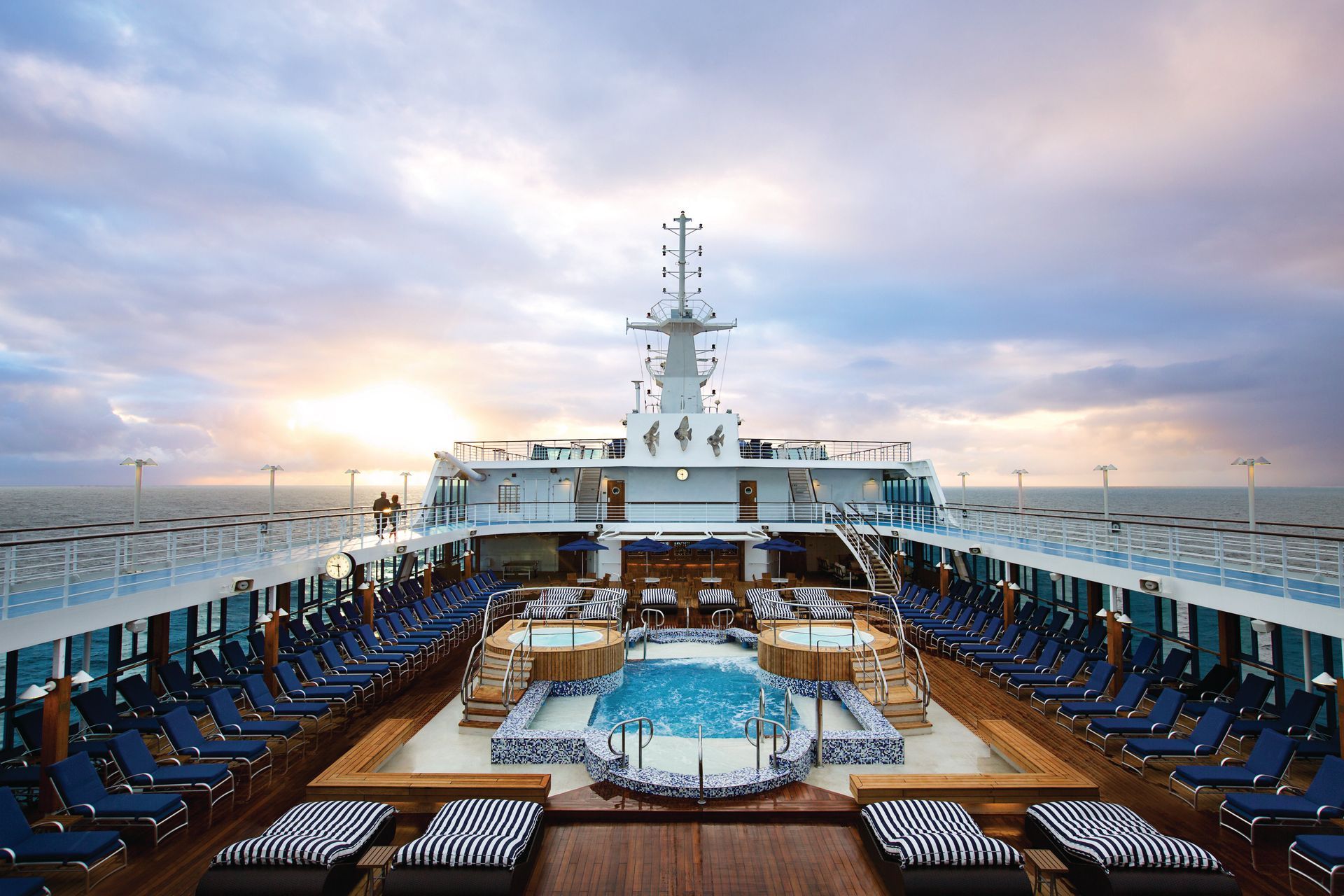 A large cruise ship with a large swimming pool on the deck.