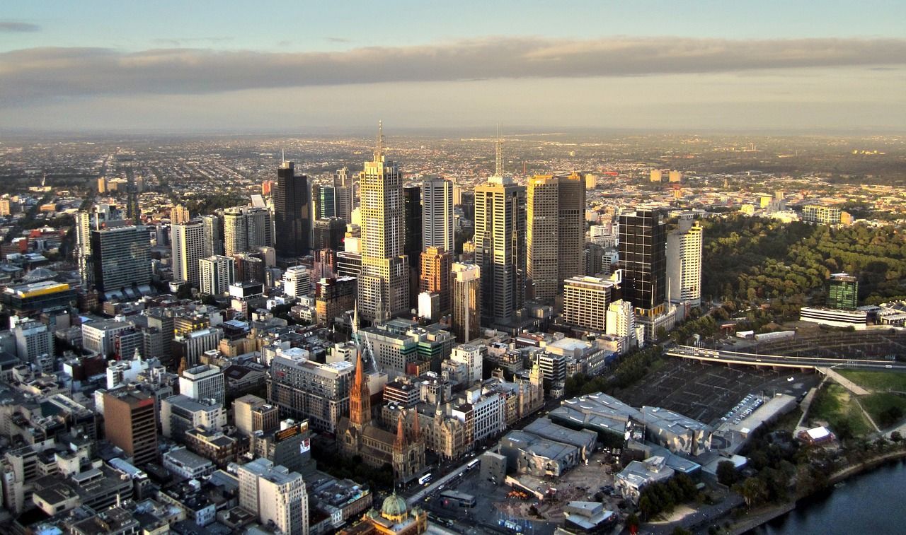 An aerial view of Melbourne city with a river in the foreground.