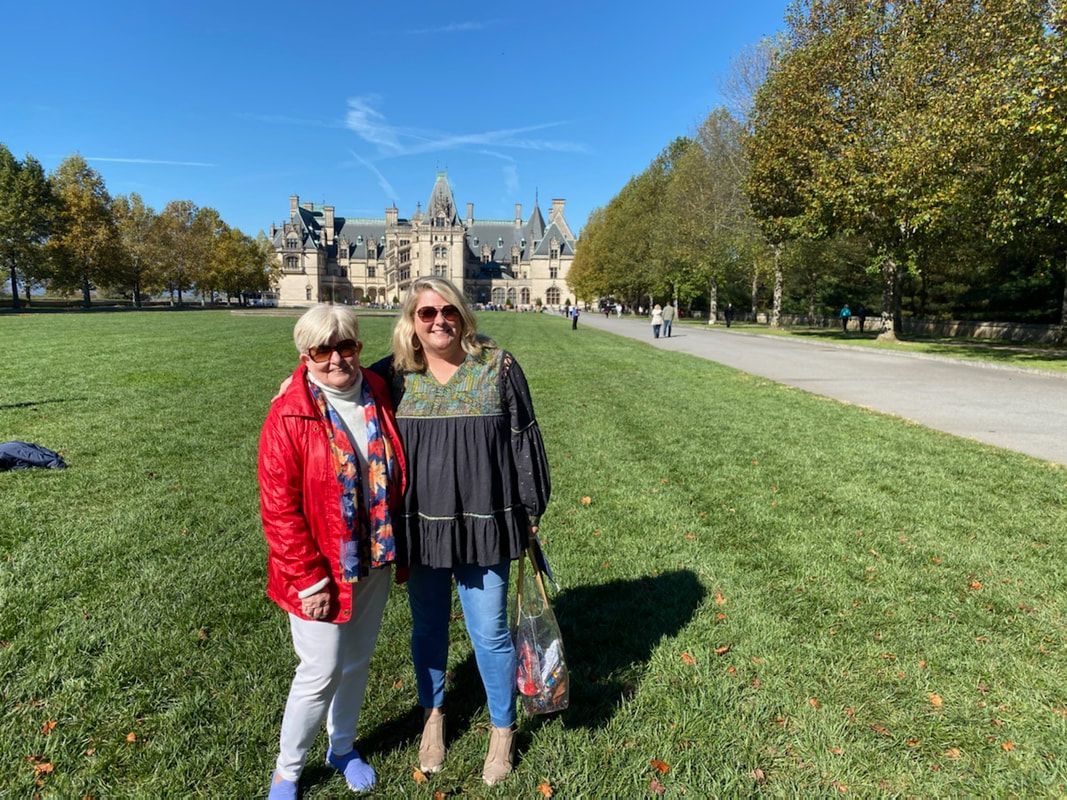 A family posing for a picture in front of the Biltmore Estate in Ashville, NC