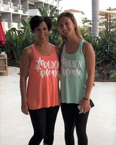 Two women wearing tank tops that say beach please are standing next to each other.
