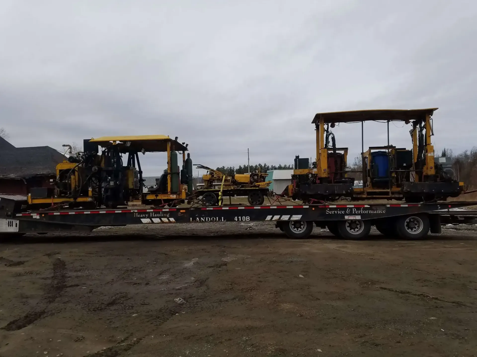 Two tractors are sitting on top of a flatbed trailer