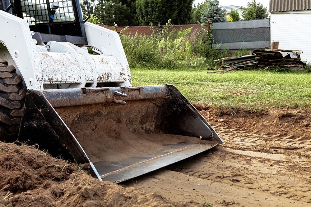 A small bulldozer is sitting on top of a pile of dirt.