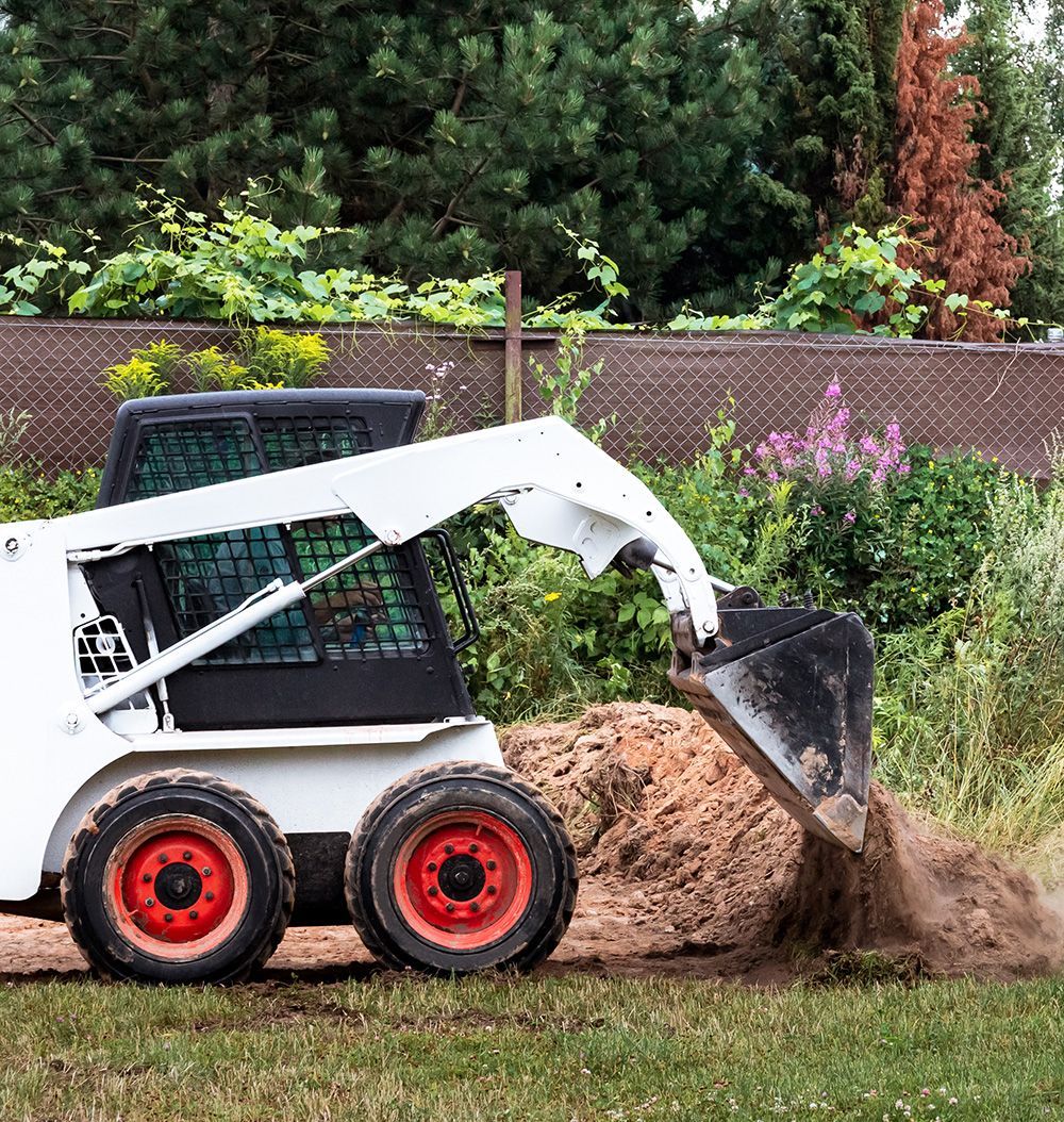 A small bulldozer is moving dirt in a field.