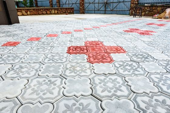 A red cross is painted on a gray and white tile floor.