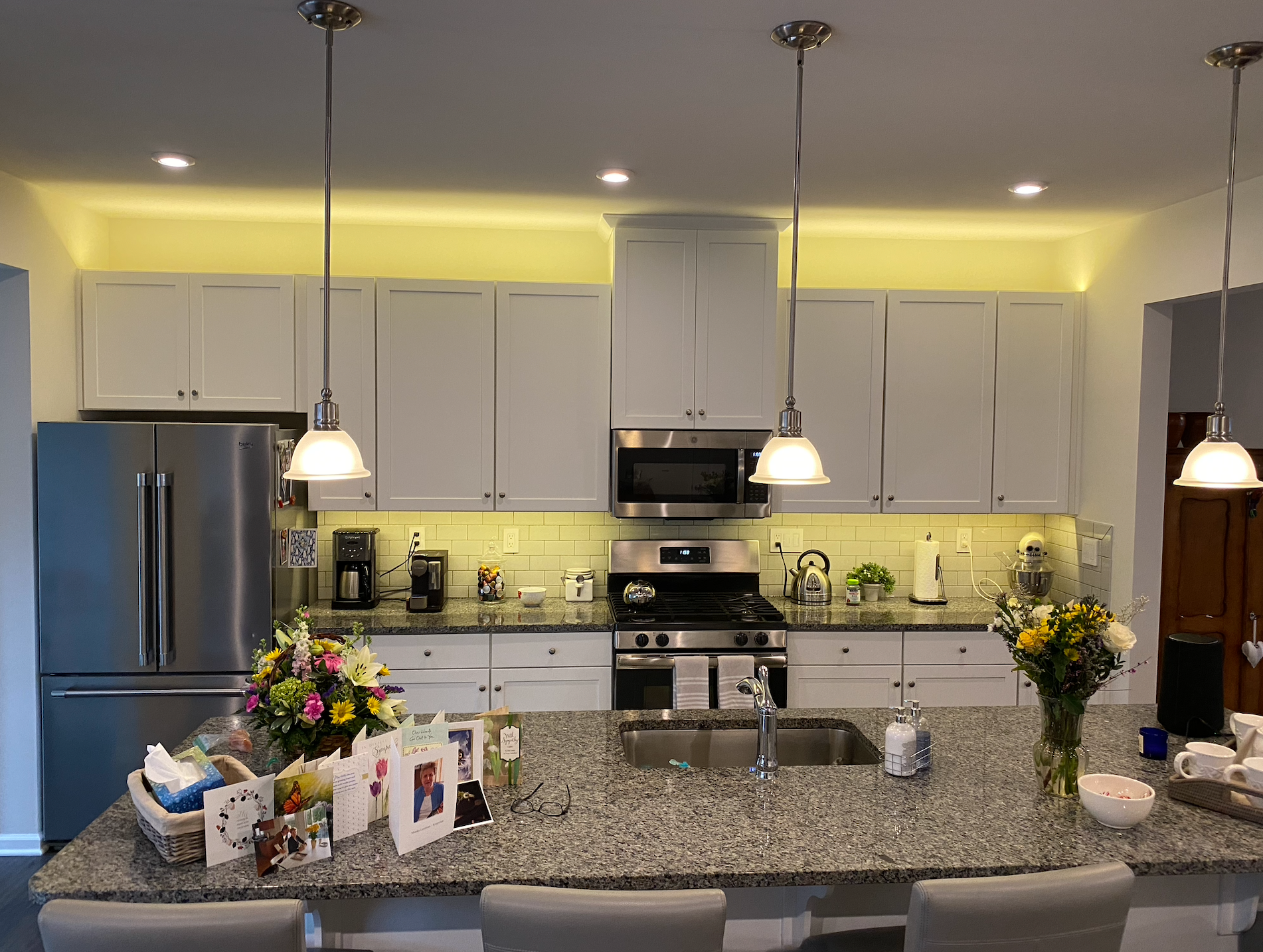 Modern kitchen with white cabinets, stainless steel appliances, and a granite countertop.